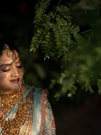 A close-up portrait of the bride with her eyes closed, bathed in soft, dappled light. This is a moment of pure peace and contentment.