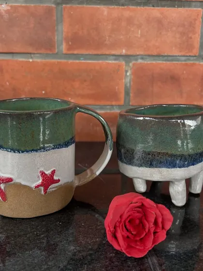 A beach-themed mug and a matching three-legged planter, created by a 12-year-old artist during her first 15-day exploration of ceramics.