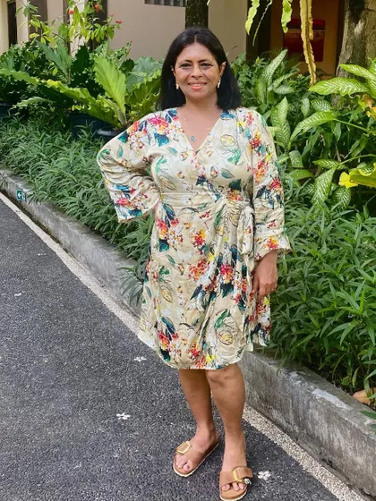 A full-length view of the tropical wrap dress. The comfortable fabric and vibrant print make it a vacation essential.