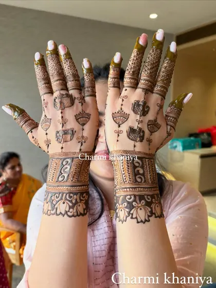 A perfect henna design for a party or smaller function. This back of hand mehendi features cute hanging jhumkis and lotus motifs for a fun and festive vibe.