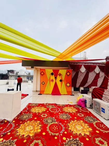 A wide shot of the rooftop Haldi setup, showing the seating arrangement and the backdrop. I can transform any space, big or small.