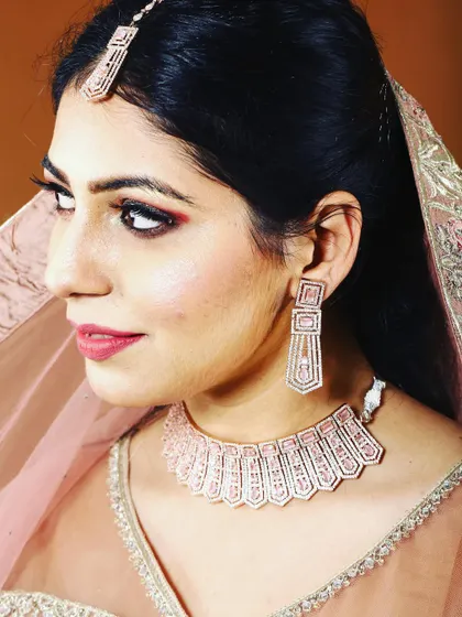 Celebrate Diwali with a complete, elegant look. This rose-gold plated necklace set with matching earrings and tikka is perfect for adding that festive sparkle.