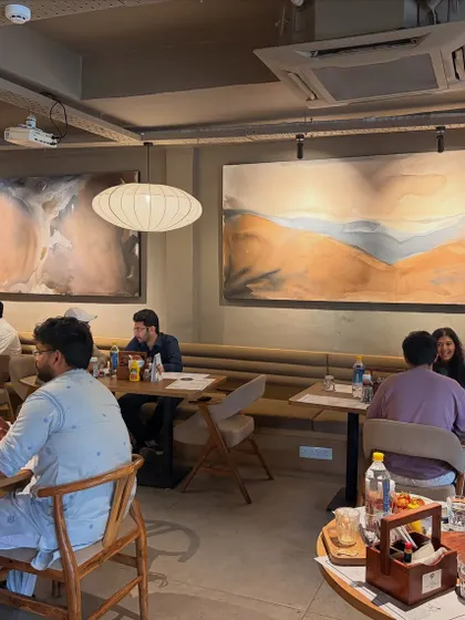 My art isn't just for homes. I love creating custom pieces for commercial spaces like this one for Sidewalk cafe in Lucknow. These large 8-foot canvases set the mood and create a memorable atmosphere for customers, making the space feel unique and curated.