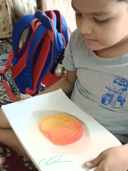 Nothing makes us prouder than seeing a student's face light up with their finished artwork. This young artist proudly displays his skillfully shaded pastel drawing of a mango, a testament to the confidence and ability gained in our classes.