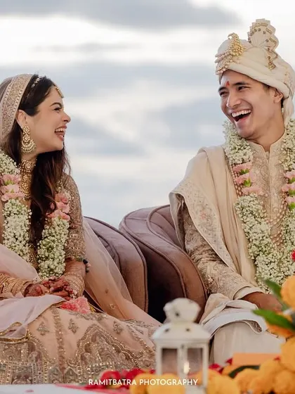 A candid moment of shared laughter between the bride and groom during their beachside wedding ceremony.