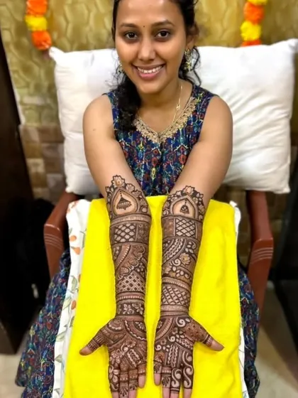 A smiling client proudly displaying her intricate full-arm mehandi. Seeing my clients happy with my work is the best reward.