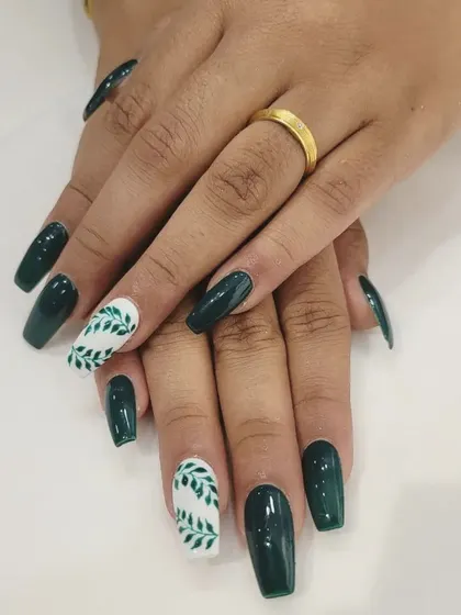 A crisp shot of our botanical nail art. The contrast between the glossy dark green and the white accent nails with leaf details creates a fresh and stylish look on these long square nails.