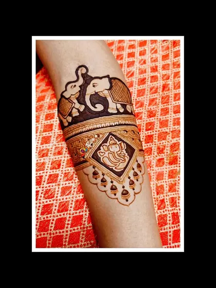 A close-up of the arm, featuring a beautiful elephant and a portrait of Lord Ganesha, perfect for starting the wedding festivities with blessings.
