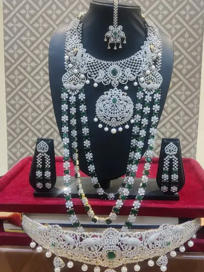 A stunning American diamond and emerald set with pearl drops, laid out on a red tray.