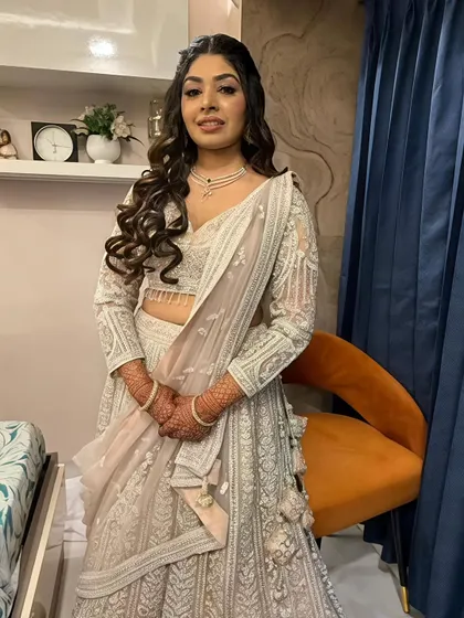 A full-length view of the stunning silver-white lehenga. The makeup is glamorous yet sophisticated, perfect for an evening of celebration.