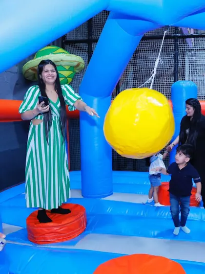 A mom joins in on the fun, playing with her child in the inflatable zone. Our play areas are designed for family interaction.