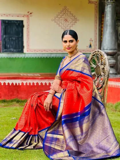 A portrait of me in a stunning red and blue Kanchipuram silk saree, a classic and regal combination.