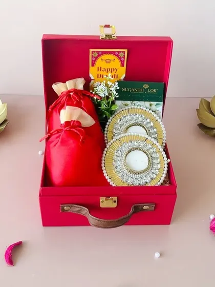 Our red suitcase box is perfect for making a bold statement. This budget-friendly option includes beautiful pearl diyas, a satin potli, and fragrant incense sticks.