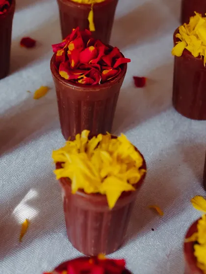 Small terracotta cups filled with red and yellow flower petals for guests to use.