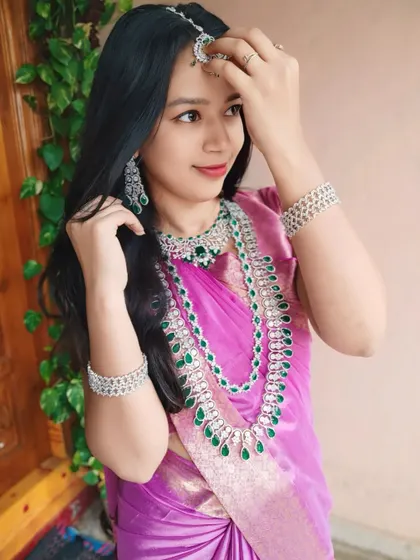 Adjusting her maang tikka, this client shows off the complete AD set, including the layered necklace, choker, and matching bracelets.