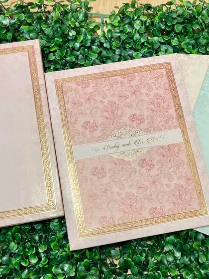 A pastel-colored invitation set with delicate floral patterns and gold foil borders. The different colored inserts add a playful touch.