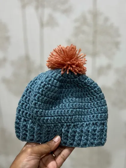 Holding up one of the finished baby beanies. You can see the texture of the crochet stitches, which makes it so cozy. I can make these in any color combination you like.