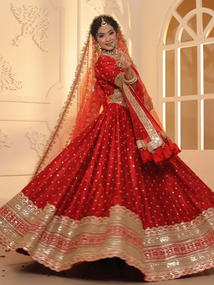 The perfect twirl in a lightweight red lehenga with a wide, embellished border. This outfit is ideal for a bride who wants a classic color without the heavy weight.