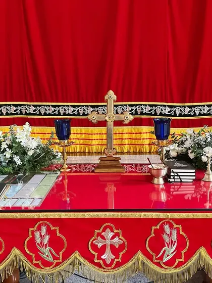 A closer look at the altar decoration for a church wedding. The setup includes two beautiful white floral arrangements and candles to create a sacred and peaceful atmosphere.