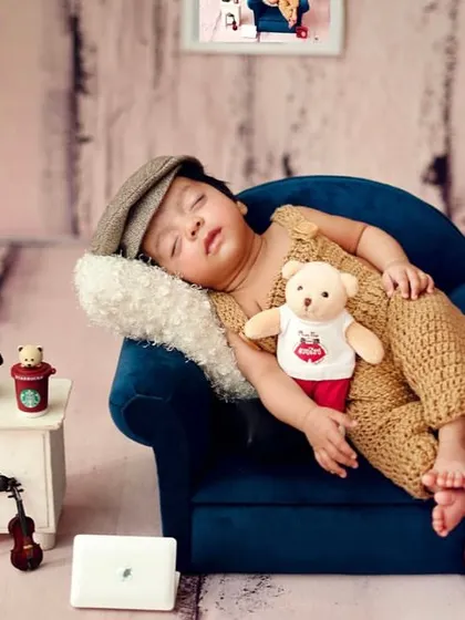 A little gentleman taking a nap. Using miniature furniture and props like this tiny sofa and telephone adds a touch of charm and storytelling to the portrait.