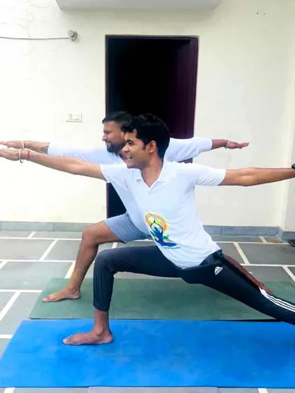 Demonstrating the correct alignment for Warrior II pose during a session for SR Goel & Associates. Proper form is key to preventing injury and getting results.