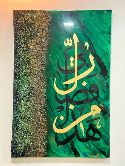 A full view of the 'Hadha Min Fazle Rabbi' artwork, showing the contrast between the smooth, marbled green resin and the rustic, textured border.