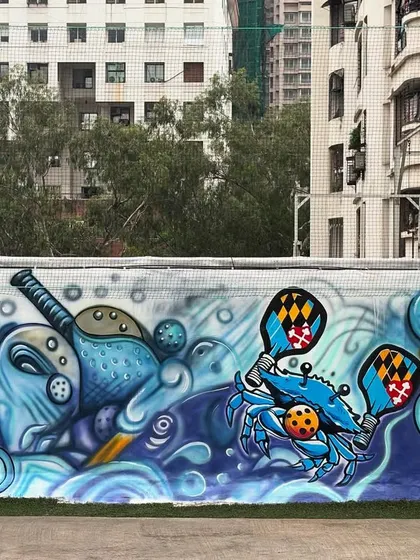 A section of the pickleball mural, showing the playful mix of sports equipment and sea creatures in a vibrant, wavy composition.