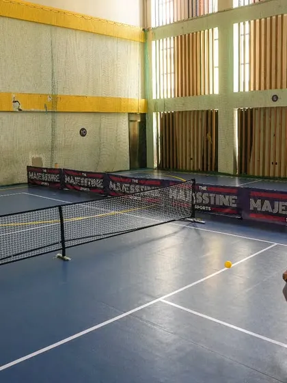 A player lunges for a low shot on our one-of-a-kind synthetic pickleball court, designed for speed and precision.