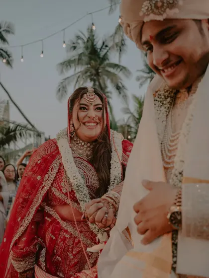 A close-up of the bride's radiant smile as she holds her groom's hand during the wedding ceremony.