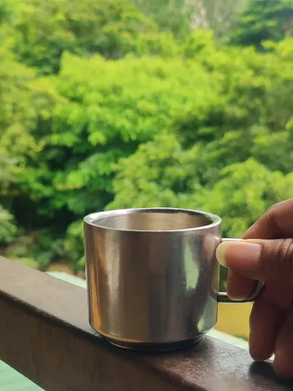 A simple cup of tea tastes better with a view of the lush green canopy at our Nandi Hills resort.