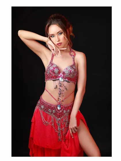 A vibrant and detailed shot for a belly dancing costume designer. The lighting is carefully controlled to highlight the intricate beadwork and rich colors of the outfit.