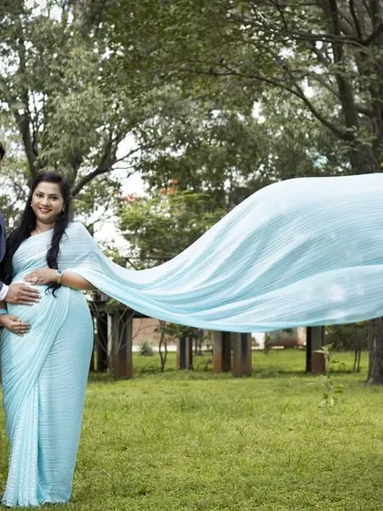 A couple looking elegant in our light blue long trail saree and a matching suit for him.