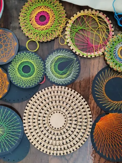A stunning collection of colorful string art pieces made on laser cut wooden bases.