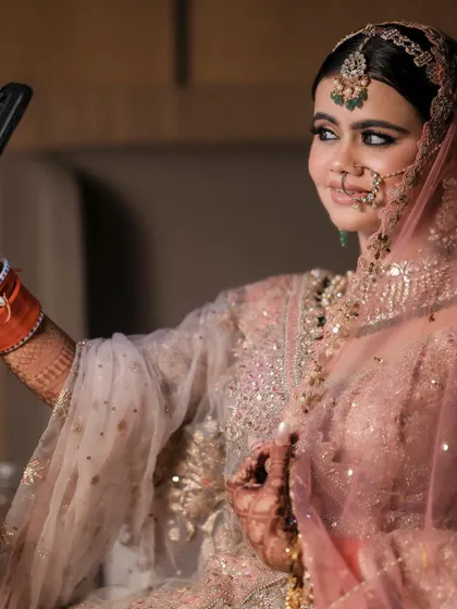 A modern bride in a candid moment, taking a selfie. This shot captures her fun personality and the reality of modern weddings, blending tradition with contemporary life.