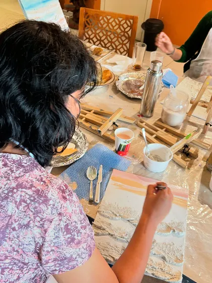 A participant adding texture to her beach painting. The details make the artwork come to life.