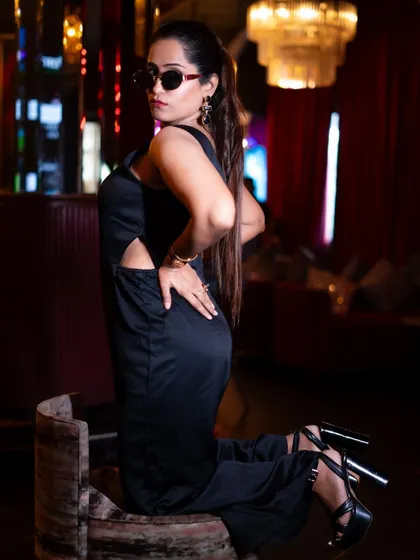 A full-body pose showcasing the black jumpsuit. This kind of shot is essential for fashion influencers to display the complete outfit.