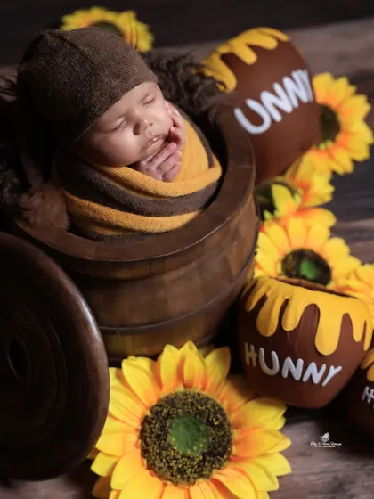 A sweet-as-honey theme for your little cub. This 'Winnie the Pooh' inspired newborn shoot features a baby nestled in a 'hunny' pot, surrounded by sunflowers for a warm and cheerful photo.