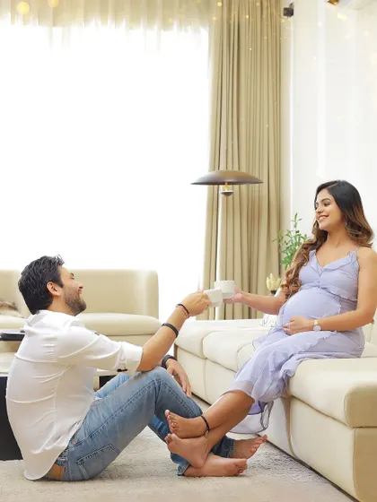 A sweet, candid moment of a couple sharing a cup of tea in their living room. At-home shoots are all about capturing your real life and love.