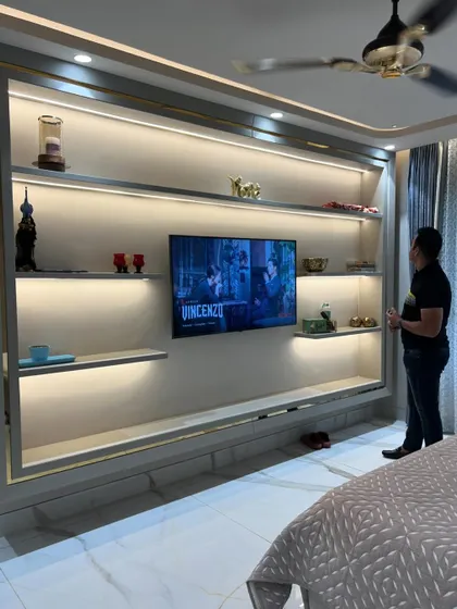 Adjusting the decor on the shelves of the media unit before the final photoshoot.