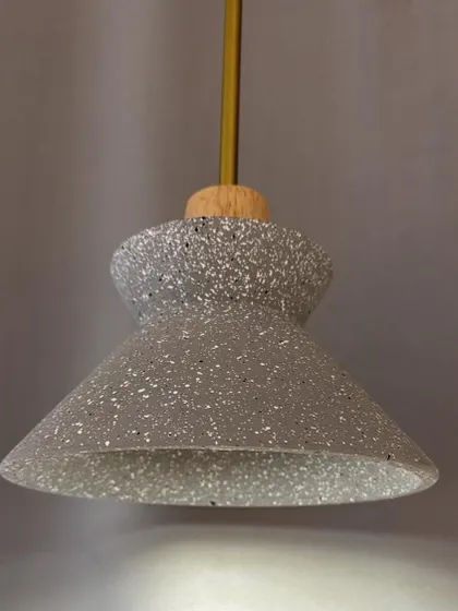 A pendant light with a terrazzo shade. The speckled pattern of the terrazzo adds a playful and modern touch.