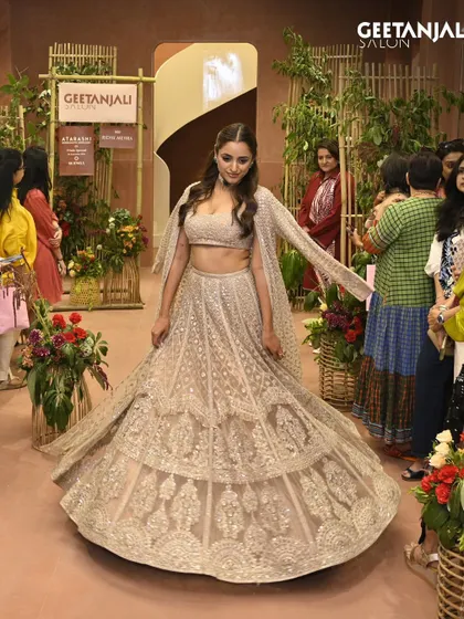 A model walks the runway at our Ahmedabad flagship launch. Her stunning lehenga is paired with soft waves and glowing makeup, a signature look from our talented team.