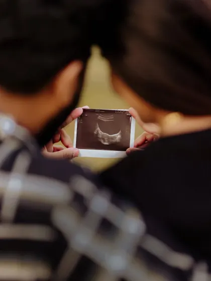 Sometimes the smallest things tell the biggest stories. This close up shot focuses on the couple holding their baby's first picture, the ultrasound scan. It is a powerful and emotional image that marks the real beginning of their new adventure.