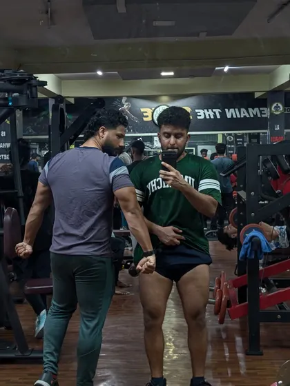 The gym is about mutual respect and competition. Here, I'm showing a client a side tricep pose, comparing progress and motivating each other to keep improving.