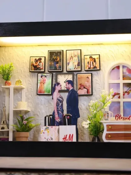 Another custom miniature theme box, designed to look like a cozy room with a photo wall, plants, and even tiny shopping bags from the couple's favorite brands.