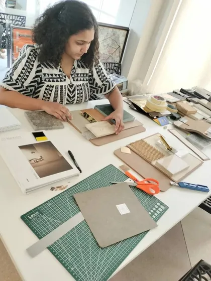 A designer at work creating a material board. This crucial step helps us visualize how different textures, colors, and finishes will interact, ensuring a cohesive and harmonious final design.