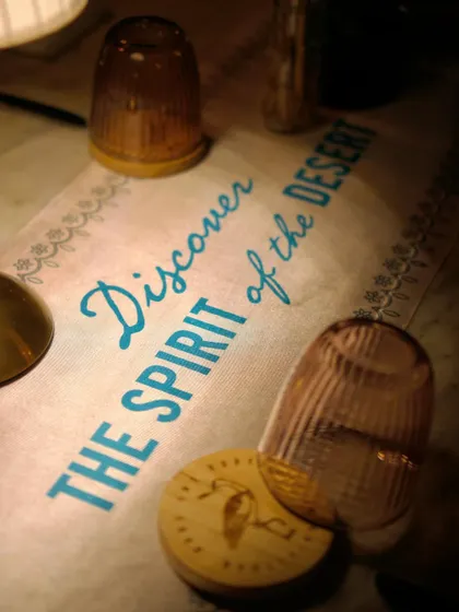 "Discover the Spirit of the Desert." A custom table runner from our Godawan whiskey collaboration, tying the event's theme directly into the dining experience.