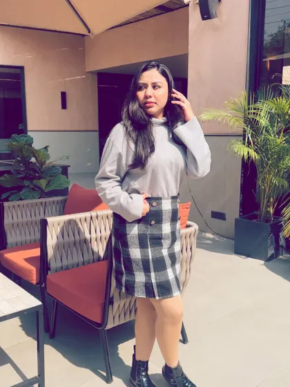 Posing at the outdoor seating area of Camo Noida, showcasing the cafe's modern and chic aesthetic.
