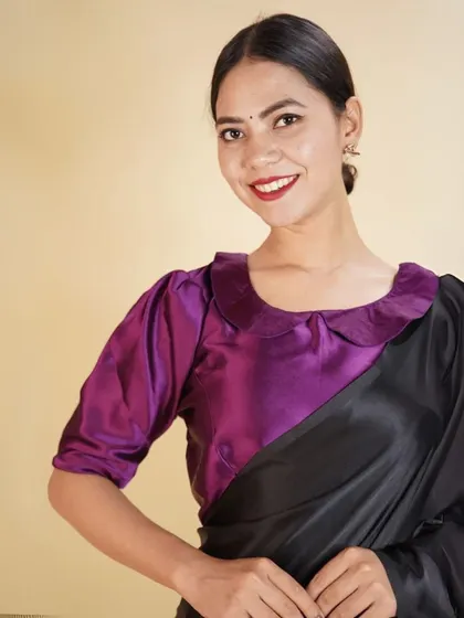 This purple satin blouse features a Peter Pan collar and puffed sleeves, perfect for adding a touch of vintage charm to your look.