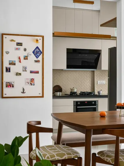 A custom magnetic board at the entrance to the 'Poorna' kitchen provides a personal space for the family's travel souvenirs.
