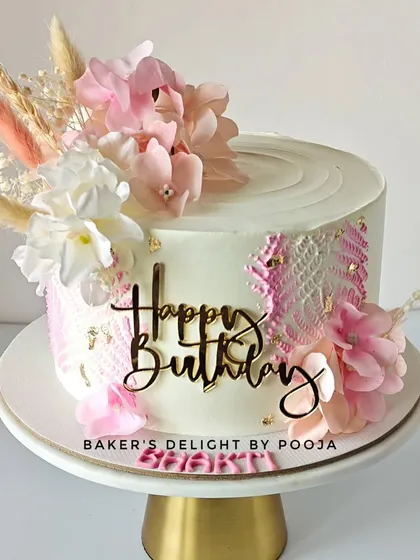 Pretty in pink and blooming with beauty. This floral birthday cake features a stenciled lace pattern and a beautiful arrangement of dried flowers for a modern, bohemian vibe.